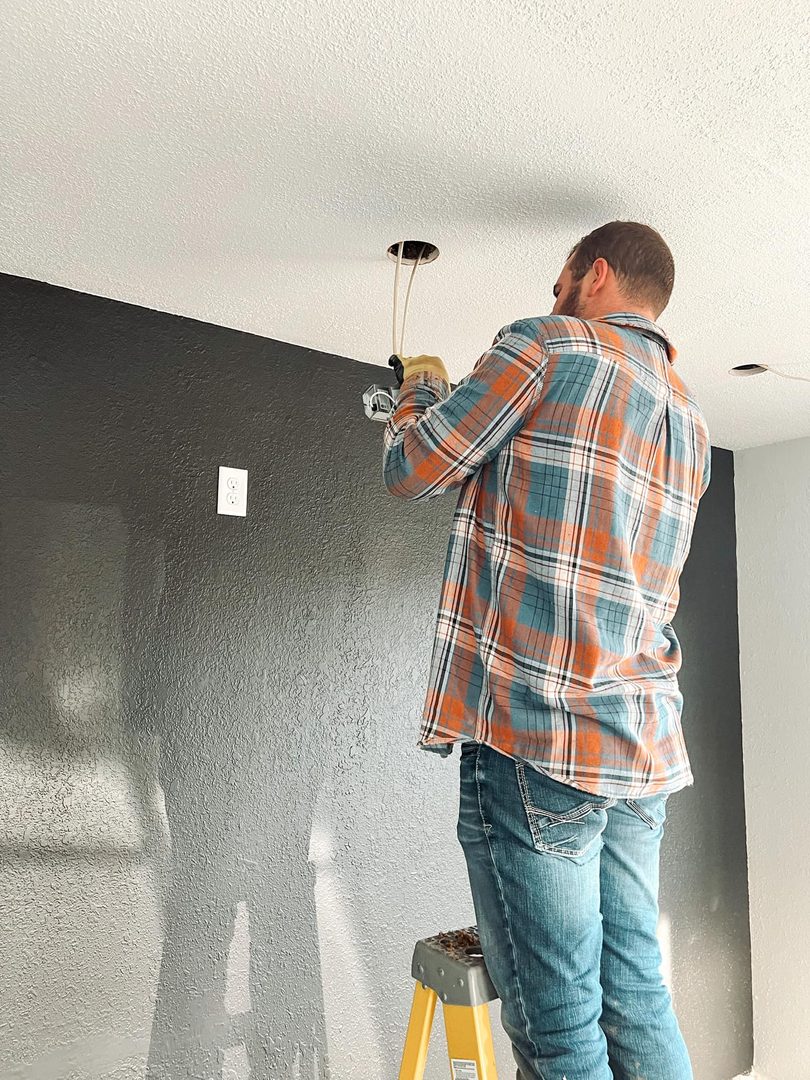 Jay, owner of Midwest Electric Contractors, installing a light fixture in a Farmington, MO home.
